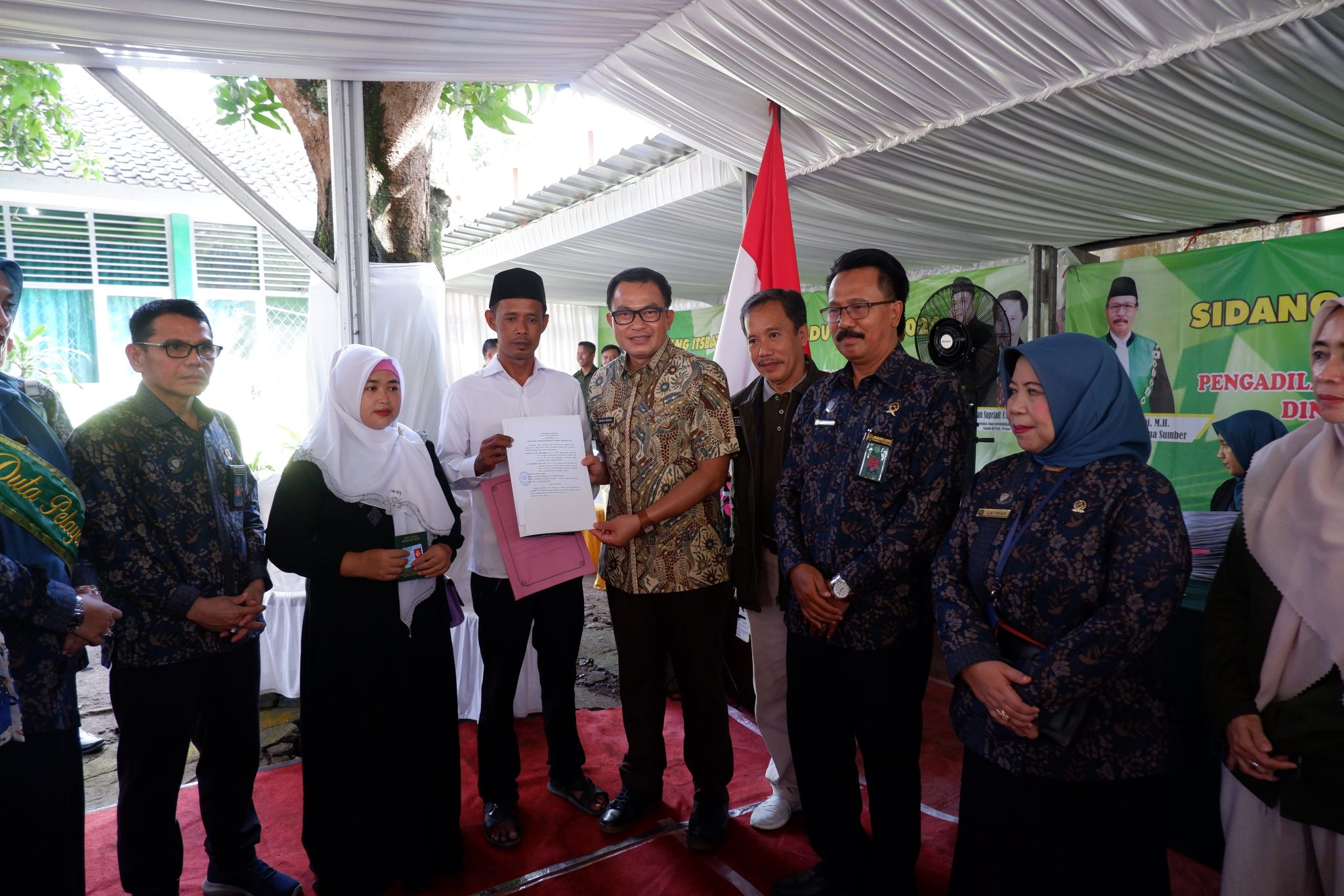 Pj Bupati Cirebon Wahyu Mijaya serahkan dokumen sidang isbat nikah kepada salah satu peserta.